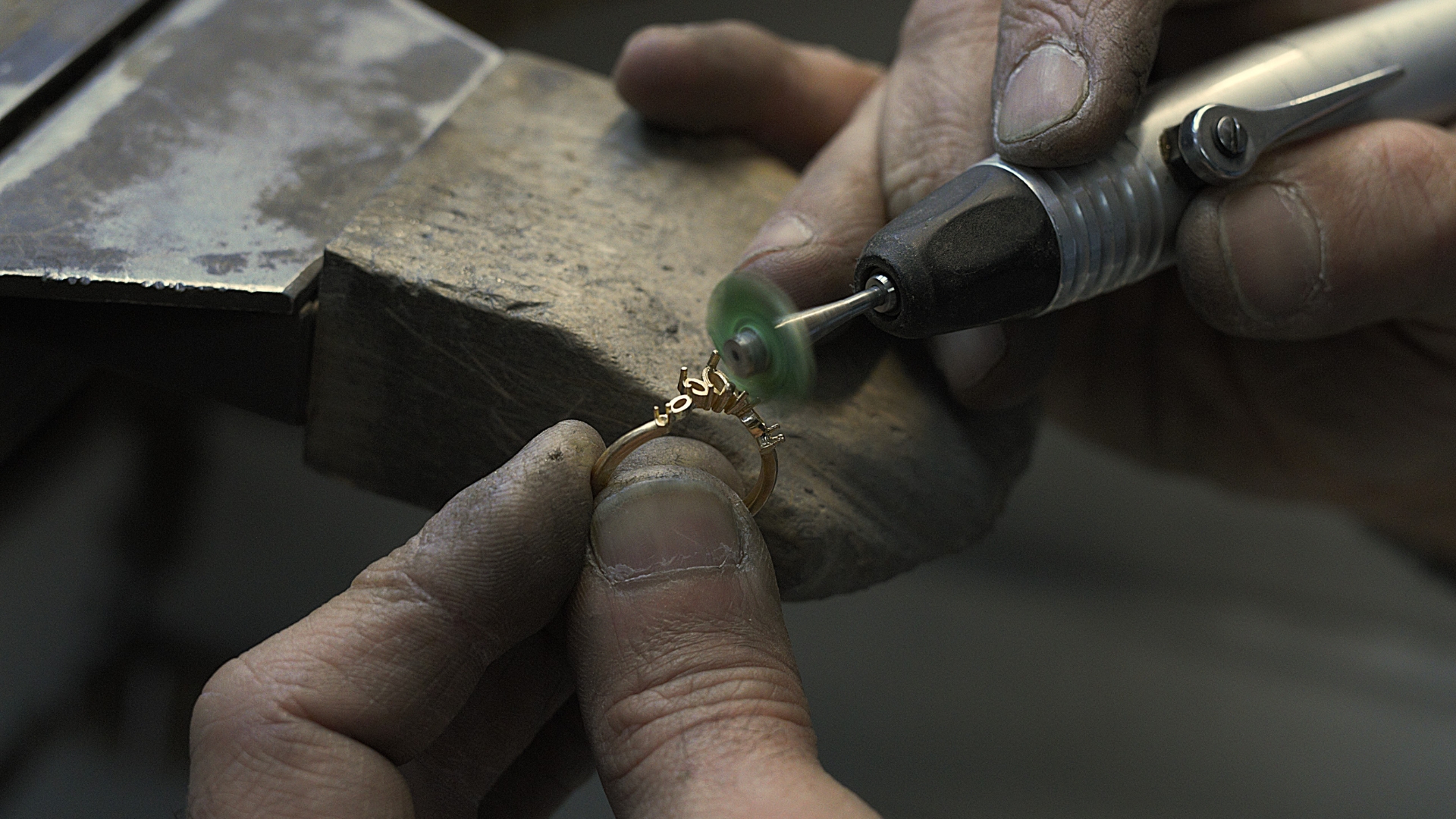 En guldsmed som noggrant väljer ut gnistrande briljantslipade diamanter för en skräddarsydd ring.